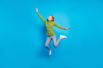 Fototapeta premium Full length body size view of pretty carefree dreamy cheerful girl jumping enjoying freedom isolated over bright blue color background
