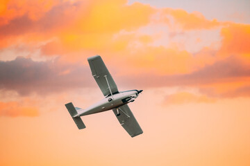 Light aircraft Flying In Sunny Sunset Sky