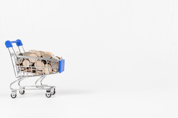 metal chrome shiny shopping trolley on wheels with nickel plated coins isolated on white...