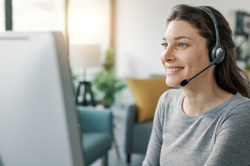 Woman wearing a headset and working with her computer