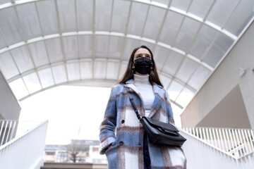 Woman with face mask walking down stairs