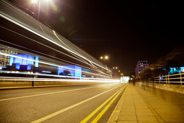 Fototapeta na wymiar Long exposure picture people and traffic crossing a bridge at night