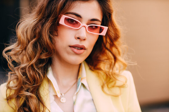 Portrait of young woman with curly hair and sunglasses
