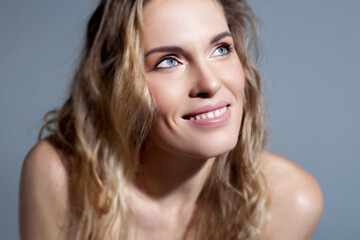 Obraz premium Beautiful blonde with wavy hair close up. Skin care, nude makeup