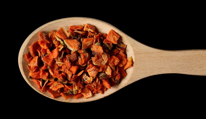 Dried and chopped carrot pieces pile isolated on black background, top view