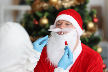 Doctor in antiplague suit taking PCR smear for coronavirus infection from santa claus