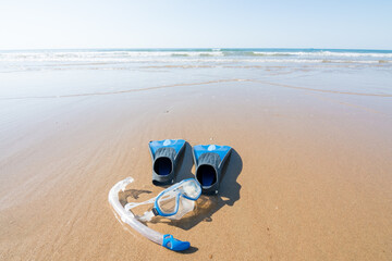 diving and snorkeling equipment on the sand of the beach. fins, mask and snorkel. leisure and water sports concept