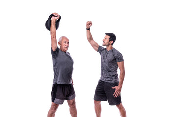 Elderly male client exercising with a fitness trainer, raises dumbbell. On a white isolated background.