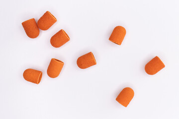 Ceramic nozzles for hardware pedicure are scattered on a white background. Pedicure tools for foot skin care. Health and beauty concept. Pedicure background. Top view, flat lay