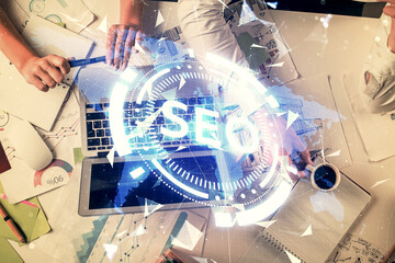 Double exposure of man and woman working together and seo drawing hologram. Technology concept. Computer background.