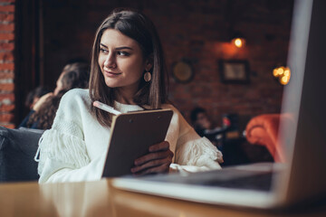 Happy woman with clipboard in light cafe