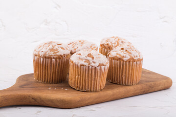 delicious fresh muffins on a wooden plate.