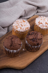 Chocolate dark muffins on wooden plate close up.