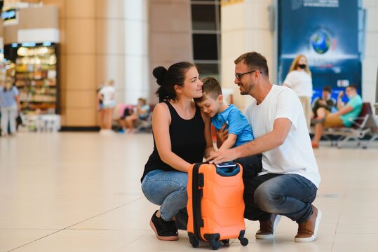 Portrait of traveling family with suitcases in airport