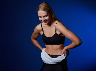 Obraz premium Image of a caucasian blonde woman in a tracksuit smiling with a towel