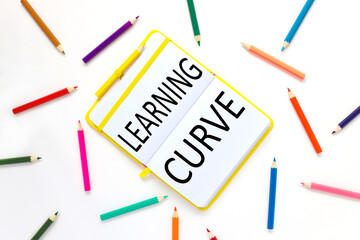 learning curve. bright open notebook on a white background and bright pencils