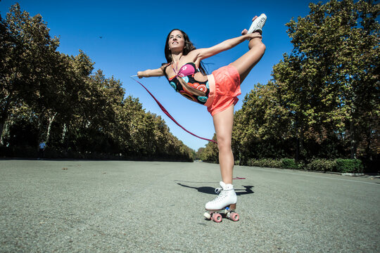 skater girl doing rhythmic gymnastics with ribbon in a park