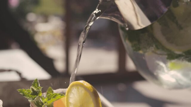 Main de jeune homme pr&eacute;pare une citronnade pour le petit d&eacute;jeuner sur un plateau   