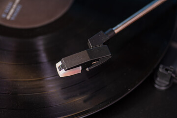 Close up shot on turntable arm hovering above record