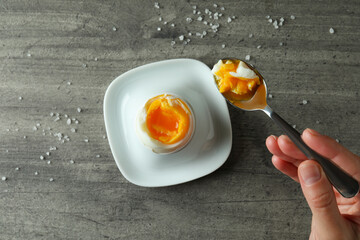 Concept of tasty breakfast with boiled egg on gray textured background
