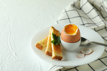 Concept of tasty breakfast with boiled egg on white textured table