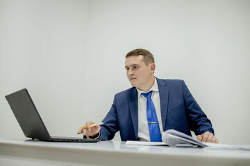 Young business man working at home with laptop and papers on desk