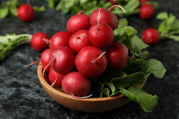 Bowl with fresh radish on black smokey table