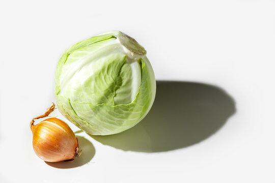 Head of cabbage, onions on a white plate. Healthy foods. Detox. High quality photo