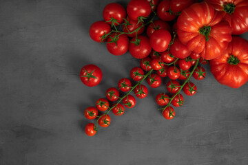Cherry tomatoes on the vine on grey stone background. Concept for healthy nutrition. Symbolic image. Copy space.