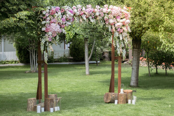 Obraz premium Wedding ceremony. Very beautiful and stylish wedding arch, decorated with various fresh flowers, standing in the garden.