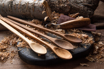 hand carved spoon with raw woods and carving tools