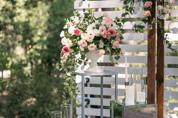 Wedding ceremony. Very beautiful and stylish wedding arch, decorated with various fresh flowers, standing in the garden.