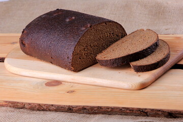 Fresh sliced rye bread loaf isolated on the wooden table and napkins