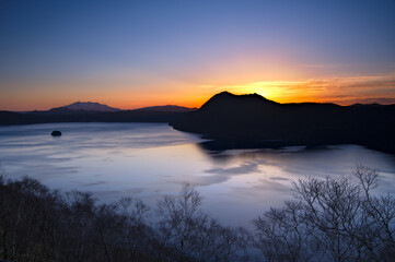 美しいグラデーションの夜明けの空と湖。日本の北海道の摩周湖。