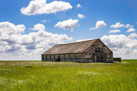 Old abandoned house made of stone on a background of sky and grass. Side view.
