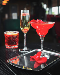 Red fruit alcohol cocktail on table. Romatic St. Valentines day cocktails.