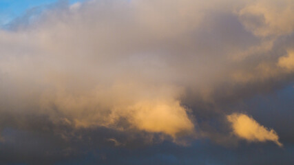 Fototapeta na wymiar Ciel partiellement envahi de cumulus, teintés de jaune