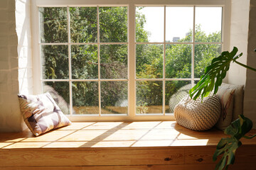 Bright scandinavian room interior with green plant monstera and sunlights, white window sill, pillows - Powered by Adobe
