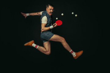 Young caucasian man playing tennis isolated on black studio background in retro style, action and...