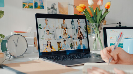 Young asia female employee listen leader on video call with diverse multiracial colleagues on online with laptop at home. Distance learning. Girl student learn online at house, Online meeting concept.