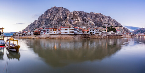 Obraz premium Old Ottoman houses evening panoramic view by the Yesilirmak River in Amasya City. Amasya is populer tourist destination in Turkey.