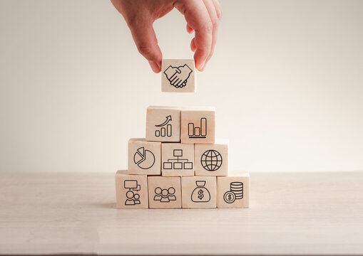Hand stack woods block step on table with icon business strategy and Action plan. business investment and development concept.