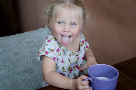 a girl drinks milk from a lilac cup