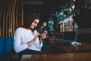 Optimistic female touching screen of smartphone