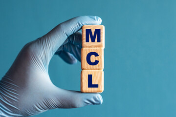 MCL is an acronym on cubes held by a hand in a blue glove