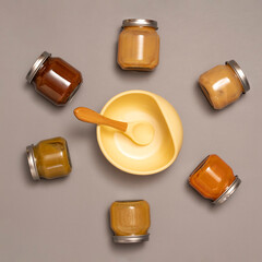 Composition with baby food accessories. Jars with baby puree, silicone bowl and spoon. Baby feeding time concept. Lunch time