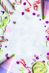 Colored party hat, sweets and confetti on stone background top view mockup