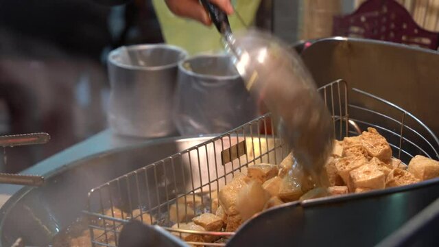 Deep frying stinky tofu popular Taiwanese dish cuisine street food at night market, must eat when visiting Taiwan.