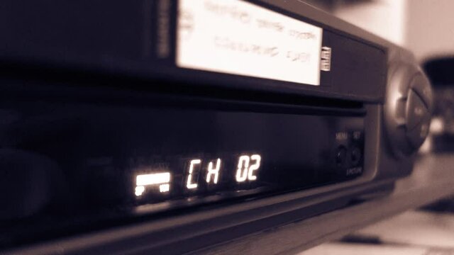 VCR timer display, ejecting the tape. Video cassette recorder, black and white