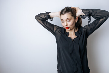 Naklejka premium A brunette woman with red lips touches her head